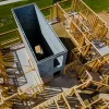 Aerial view of a residential construction site with wooden framework and concrete foundation, showcasing a residential construction company