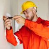 young-builder-in-orange-work-clothes-and-yellow-ha-2021-08-26-18-52-37-utc